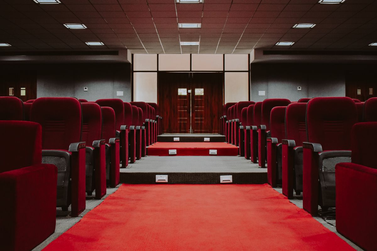 Auditório com fileiras de poltronas e corredor central